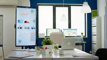 Bright business office desk ready for morning meeting with financial charts on screens, in empty conference room. Brainstorming area with nobody in it, strategy and statistics zone in start up company photo