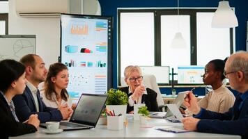 Group of diverse business people discussing with partners on call during meeting sitting in conference room. Internet conference call technology talk with investors, corporate brainstorming via web photo
