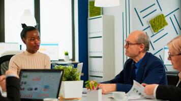Woman boss leader discussing new project using paperwork with multiethnic team at meeting broadroom, confident businesswoman mentor ceo executive consulting corporate diverse businesspeople group photo