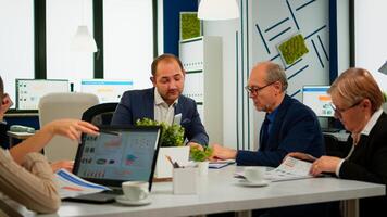 Businessman in suit talking to diverse business people partners sitting at conference table. Project leader discussing with teamworkers in meeting broadroom, group negotiations speaking with clients photo