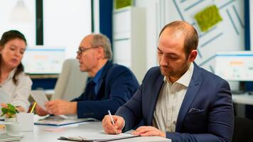 Businessman reading paper document, discussing contract with confident partner, signing investment papers. Executive director meeting shareholders in start up office, making satisfactorily agreement. photo