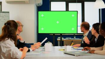 Tv green screen mockup ready for presentation placed in front of desk while business people working in broadroom. Employees using digital chroma key interactive whiteboard with mock up display monitor photo
