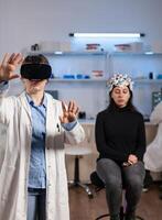 Laboratory doctor experiencing virtual reality using vr goggles in medical neurological research lab. Physician therapist using medical innovation equipment device glasses, analysing brain scan. photo
