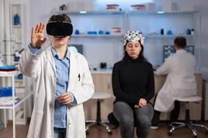 Professional researcher wearing virtual reality glasses using medical inovation in lab analysing brain scan of patient. Team of neurological doctors working with equipment high tech simulator device. photo