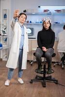 Brain scientis and patient in laboratory looking at virtual display using high tech medical science. Scientists working with healthcare simulator. Neurology physician analysing brain scan. photo
