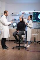 Professional neurological researcher explaning treatment result while medical scientist adjusting eeg headset preparing for brain scan analysing electrical activity, nervous system photo