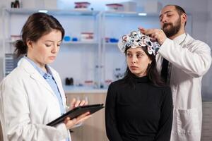 Team neurological doctors working together developing treatment for diagnosis of disease, explaning eeg results, health status, brain functions, nervous system and tomography scan. photo
