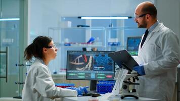 Chemists coworkers planning conducting vaccine against new virus in modern equipped laboratory. Chemists stuff analysing evolution using high tech for researching treatment against covid19 photo