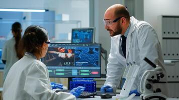 Team of scientists worried about virus evolution discussing in equipped laboratory pointing at computer. Stuff examining vaccine development using high tech researching treatment against covid19 virus photo