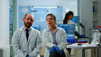 Team of researchers looking at virtual display with touchscreen, virtual reality using medical inovation in lab, gesticulating. Scientists working with equipment device, future, healthcare, vision, simulator photo
