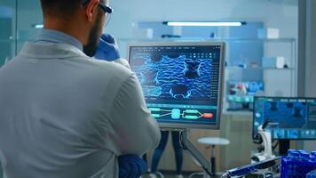 Scientist working in laboratory analysing test trial vaccine checking drug data standing in front of pc. Group of chemists examining virus evolution using high tech for research diagnosis photo