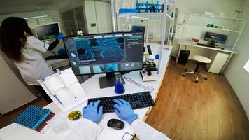 POV of technologist doing laboratory test examining sample, chemist holding tube with liquids inside. Scientist working with various bacteria tissue and DNA scan image, examining vaccine evolution photo