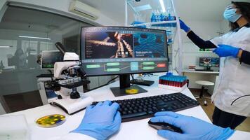 POV of man biologist checking DNA information typing on pc in modern equipped laboratory. Scientists examining vaccine evolution in medical lab using high tech, chemistry tools for scientific research photo