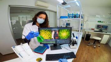 POV of laboratory medical stuff disscussing about vaccine development holding chemical container with green sample. Scientist working with DNA scan image in modern equipped laboratory using high tech photo