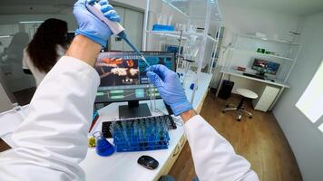 POV of scientist using micropipette in lab to extract blue liquide from test tubes analysing chemical reaction. Doctor examining virus evolution using high tech and chemistry tools for research photo