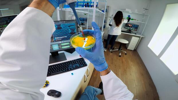 POV of scientist using micropipette for analysing blood sample putting in petri dish. Team of researchers examining virus evolution using high tech for vaccine development against covid19 photo