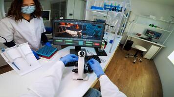 FPV of biotechnology scientist researching in laboratory using microscope analysing various bacteria. Chemist examining virus evolution using high tech for scientific research of vaccine development photo