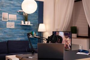 Podcast home studio in living room with professional brodcasting gear with nobody in it. Influencer recording social media content with production microphone, digital web internet streaming station. photo