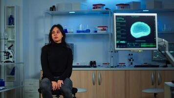 Wired patient waiting scientist doctor in neurological research laboratory visiting scientists examining tomography scan. Woman sitting in lab equipped for development of experiments photo