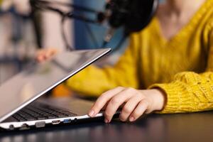 Social media influencer opening laptop starting to record new podcast from home studio. On-air online production internet broadcast show host streaming live content, recording digital vlog. photo