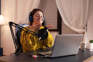 Vlogger speaking with follower on live using professional microphone wearing headphones. Creative online show On-air production internet broadcast host streaming live content, recording digital social. photo
