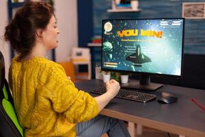 Professional gamer playing and winning in space shooter online game on powerful computer. Pro esports player streaming cyber performing gaming tournament in cyberspace using network wireless. photo
