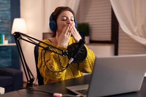 Vlogger speaking with follower on live using professional microphone wearing headphones. Creative online show On-air production internet broadcast host streaming live content, recording digital social. photo