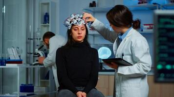 Professional doctor in neuroscience developing treatment for neurological diseases examining patient evolutions. Doctor researcher adjusting EEG headset analyzing brain functions and health status photo