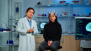 Researcher and patient with eeg headset looking at virtual display with touchscreen, virtual reality using medical inovation in neurological research lab. Scientists working with healthcare simulator photo