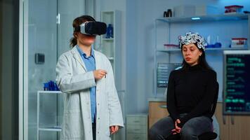 Professional researcher wearing virtual reality glasses using medical inovation in lab analysing brain scan of patient. Team of neurological doctors working with equipment high tech simulator device photo