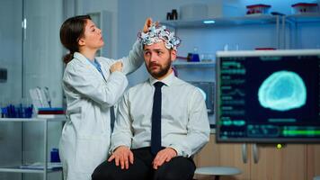 Patient with brain scan discussing with researcher neurological doctor while adjusting brainwave scanning headset examining diagnosis of disease, explaning eeg results, health status, brain functions photo