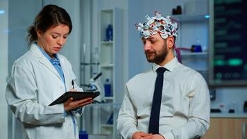 Expert research doctor in neuroscience developing treatment for neurological diseases discussing patient evolution using tablet. Doctor researcher analyzing brain functions and health status photo