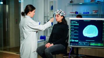 Medical researcher in neurological medicine preparing patient for examining brain functions using high tech and neurology tools for scientific research in technologically advanced lab office photo