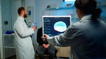 Science doctor looking at computer with medical brain scan film showing on monitor in neurology clinic. Woman sitting in neurological scientific laboratory treating nervous system dysfunctions photo