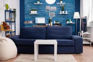 Modern living room with nobody in with blue furniture and walls, beautiful decorated. Pretty simple decor of apartment. Elegant retro decoration, cozy. photo