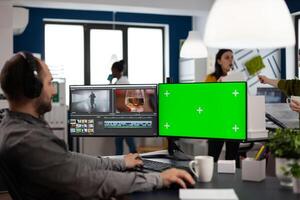 maker editor editing movie project using post production software working in post production agency at pc with green screen, chroma key, mock up isolated display. Man processing audio montage photo