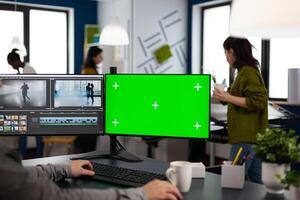 editor using computer with chroma key, mock up isolated display editing project and audio footage. Videographer editor processing film montage on pc with green screen photo