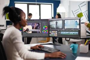 Black woman videographer developing project film montage sitting in creativity agency studio. editor creator in digital multimedia company editing movie with post production software photo