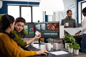 Team of editors women working with modern studio post production software in digital multimedia company. maker employees editing film montage in creative agency looking at computer photo
