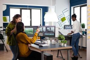 Coworkers talking about movie project looking at film footage working in creative start up agency office with two monitors. Videographers processing montage with post production software photo
