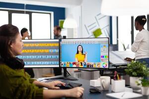 Photographer retoucher woman working on computer with photo editing software. Professional graphic editor retouching assets of client with stylus pencil and two monitors in creative production company