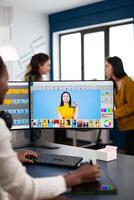 Black retoucher artist analysing images on pc with two monitors and retouching digital assets with stylus pencil. African designer using photo editing software working in creative production office