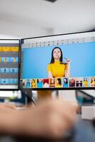 Close up of woman editor retoucher holding stylus pencil moving on graphic tablet editing digital photo using computer with two displays. Photographer retouching assets in production agency