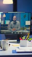 Woman freelancer discussing with client on call at midnight from business office using headphone. Corporate team using group conference technology talking on webcam during online meeting photo