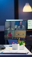 Businesswoman talking during conference with team in midnight using pc in start up business office. Corporate meeting using technology network wireless discussing on webcam late at night photo