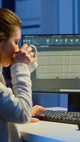 Freelancer architect working in 3D software to elaborate container design sitting at desk in business office at midnight. Focused engineer creating and studying prototype, analysing scale model. photo