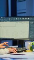 Woman architect matching digital plans from pc with blueprints working in start-up business office overtime. Designer using cad software to design a 3D concept of buildings creating late at night photo