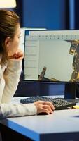 Tired woman architect working on modern cad program overtime sitting at desk in start-up office. Industrial female engineer studying prototype idea on pc showing cad software on device display photo