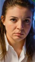 Close up of overworked business woman looking exhausted at camera sighing working late at night in start-up business office. Focused employee using technology network wireless doing overtime for job photo