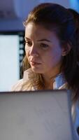 Freelancer typing on laptop late at night standing in start up business office late at night working. Busy focused employee using modern technology network wireless doing overtime for job searching photo